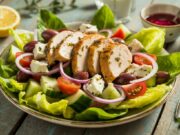 Exciting New Greek Salad and Chicken: Frugal Feast Greek salad and chicken slices served on a colorful Greek salad with tomatoes, cucumbers, olives, red onion, and feta cheese.